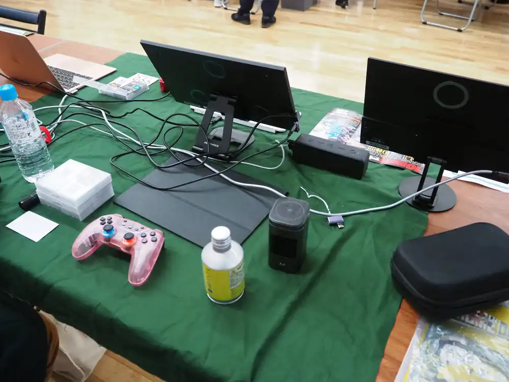 試遊ブースの裏側、ケーブルとコントローラがごちゃつく出展者側
