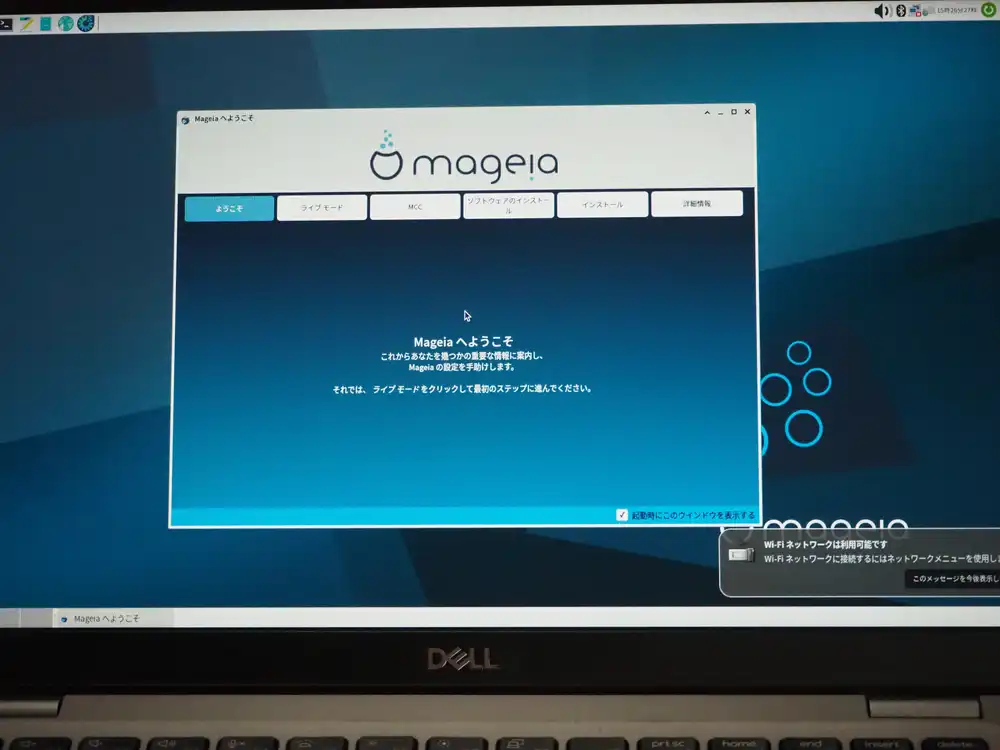 Mageia Welcome screen. Welcome dialog with tabs over an Xfce desktop, "Wi-Fi network available" notification at bottom right